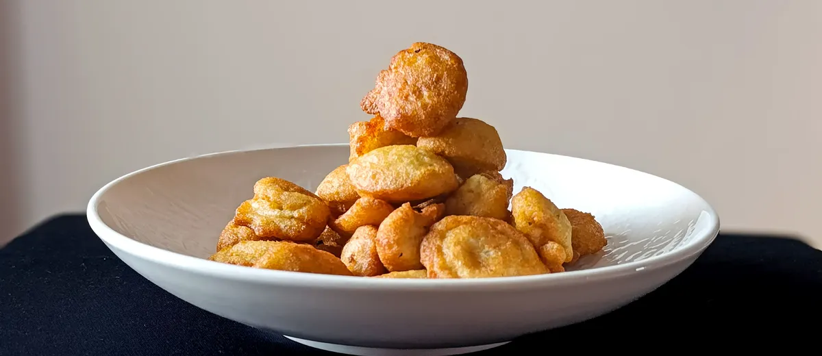 Accara sénégalais, beignets de haricots niébé dorés et croustillants empilés, servis avec une sauce tomate pimentée.