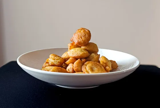 Accara sénégalais, beignets de haricots niébé dorés et croustillants empilés, servis avec une sauce tomate pimentée.