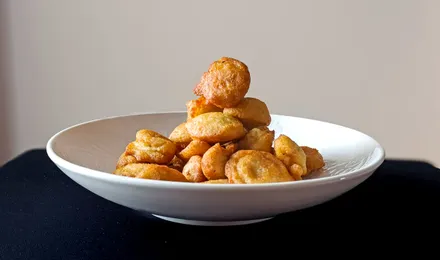 Accara sénégalais, beignets de haricots niébé dorés et croustillants empilés, servis avec une sauce tomate pimentée.