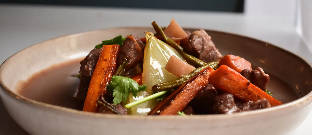 Cocotte de bœuf bourguignon mijoté au vin rouge avec lardons, carottes et champignons