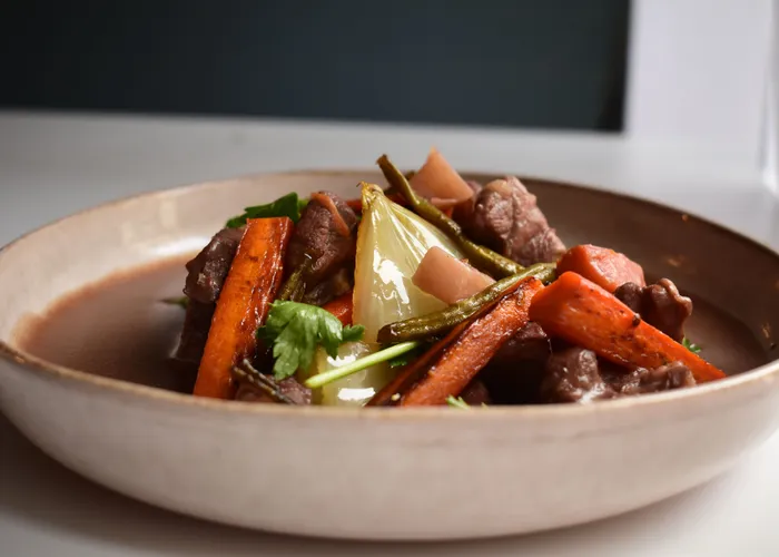 Cocotte de bœuf bourguignon mijoté au vin rouge avec lardons, carottes et champignons