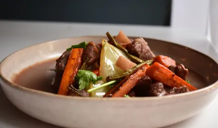 Cocotte de bœuf bourguignon mijoté au vin rouge avec lardons, carottes et champignons