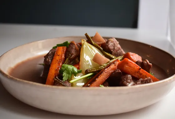 Cocotte de bœuf bourguignon mijoté au vin rouge avec lardons, carottes et champignons