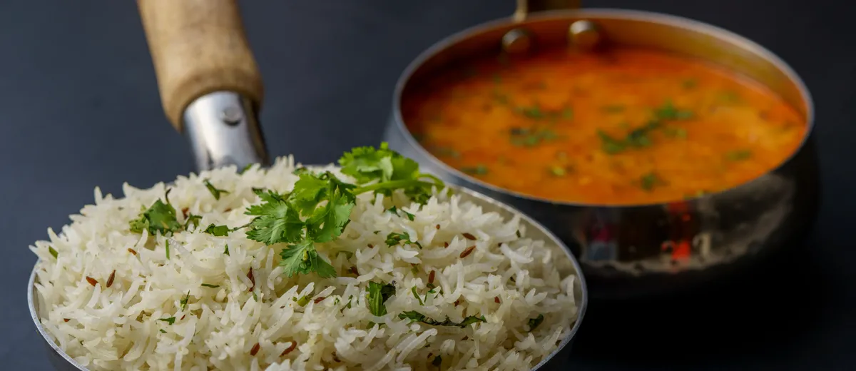 Butter chicken, poulet en sauce tomate crémeuse orange-rouge parsemée de coriandre, servi avec du riz basmati et du naan