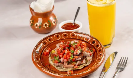 Ceviche de poisson blanc à la mexicaine dressé sur tostadas, parsemé de coriandre, dés de tomate et lamelles d'avocat.