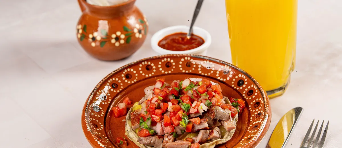 Ceviche de poisson blanc à la mexicaine dressé sur tostadas, parsemé de coriandre, dés de tomate et lamelles d'avocat.