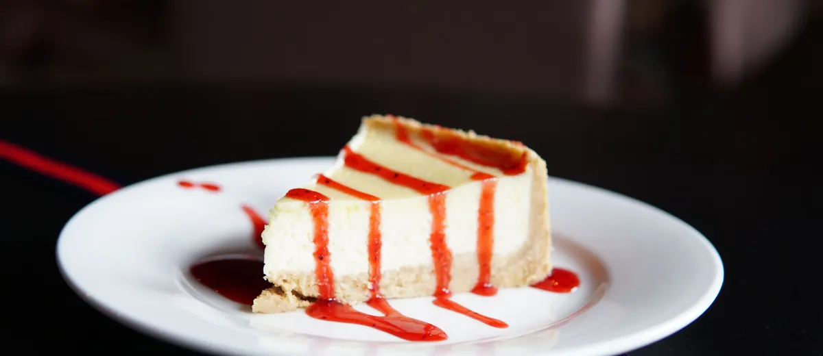 Part de New York cheesecake à la texture dense et crémeuse sur une base de biscuits sablés