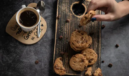 Cookies moelleux aux pépites de chocolat noir, dorés et légèrement craquelés, refroidissant sur une grille