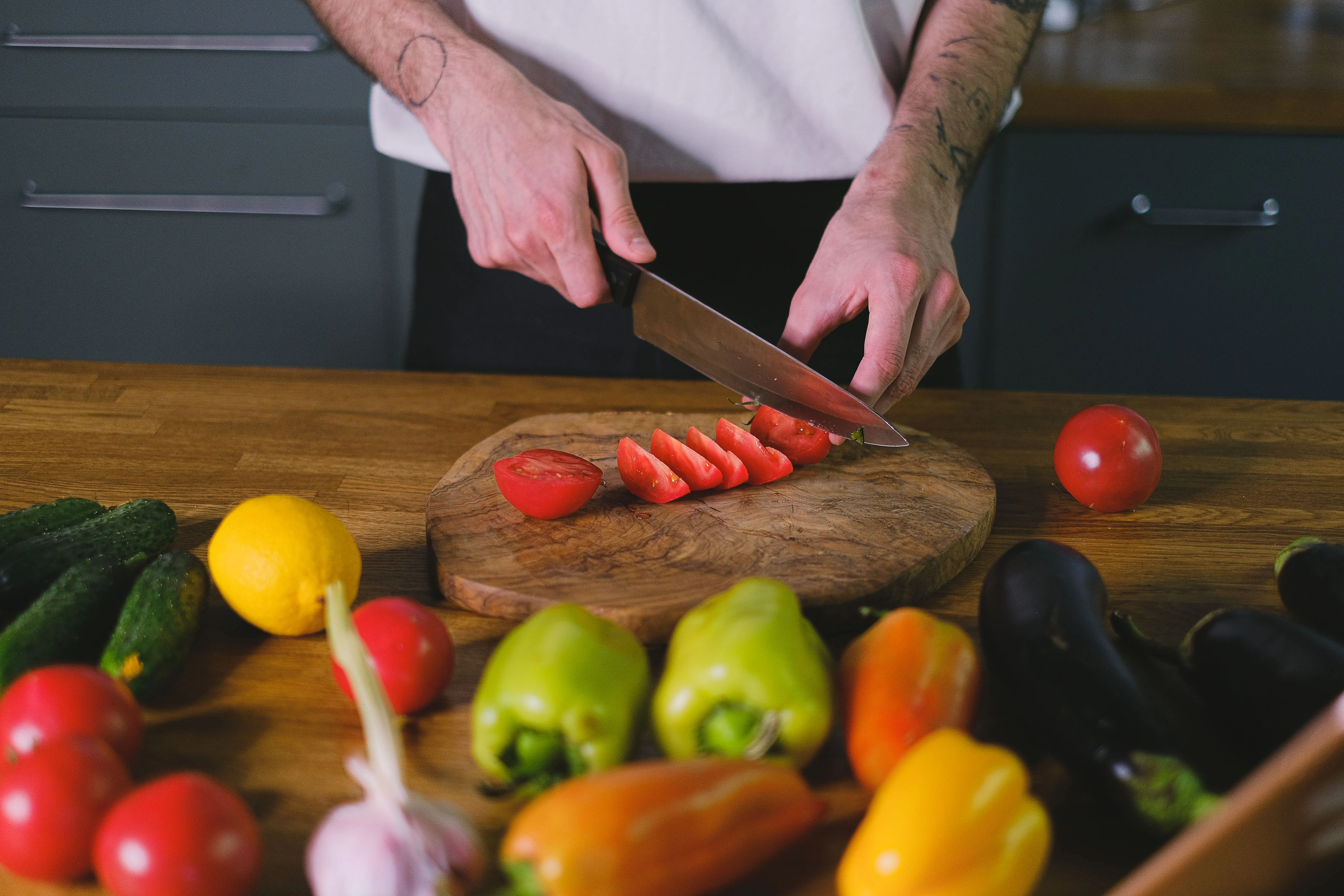 Un couteau de chef en train d'émincer un oignon sur une planche en bois