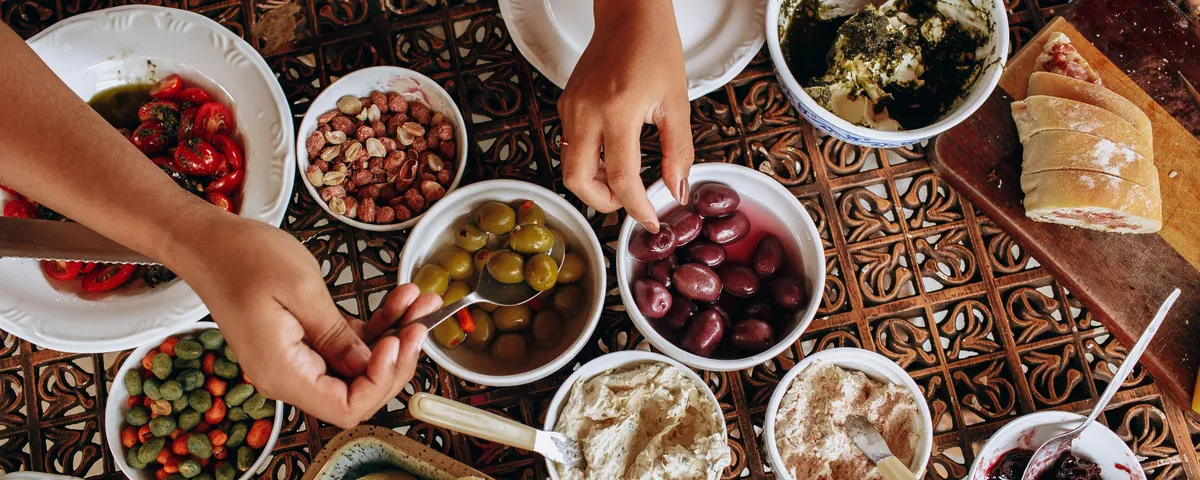 Table de plats italiens variés : pâtes fraîches, risotto, focaccia et un verre de vin blanc