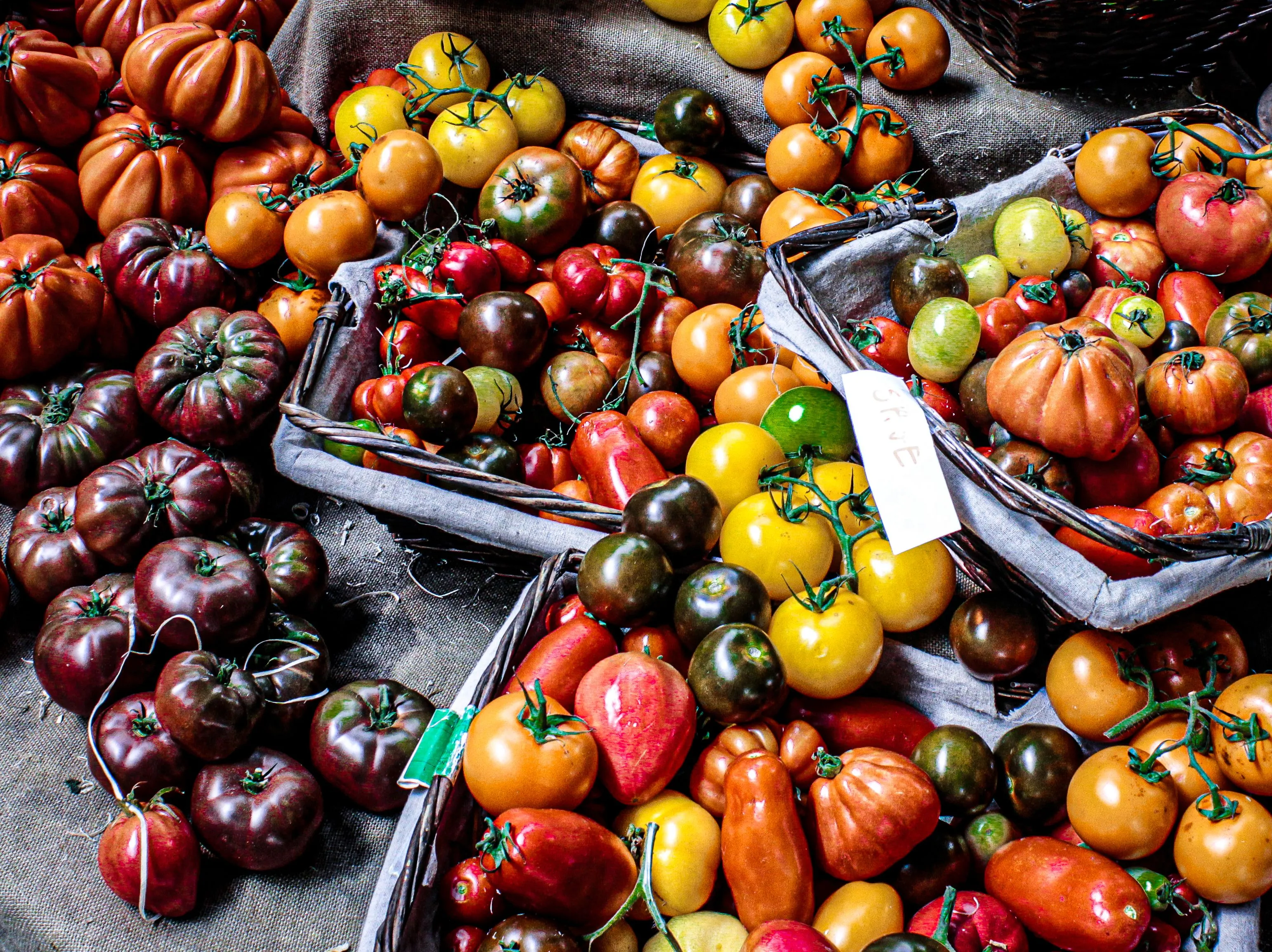 Étal de marché couvert de tomates anciennes de formes et de couleurs variées
