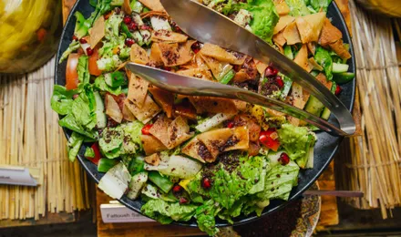 Fattouche libanaise, salade colorée de laitue, tomates, concombre et radis parsemée de sumac et de morceaux de pain pita grillé