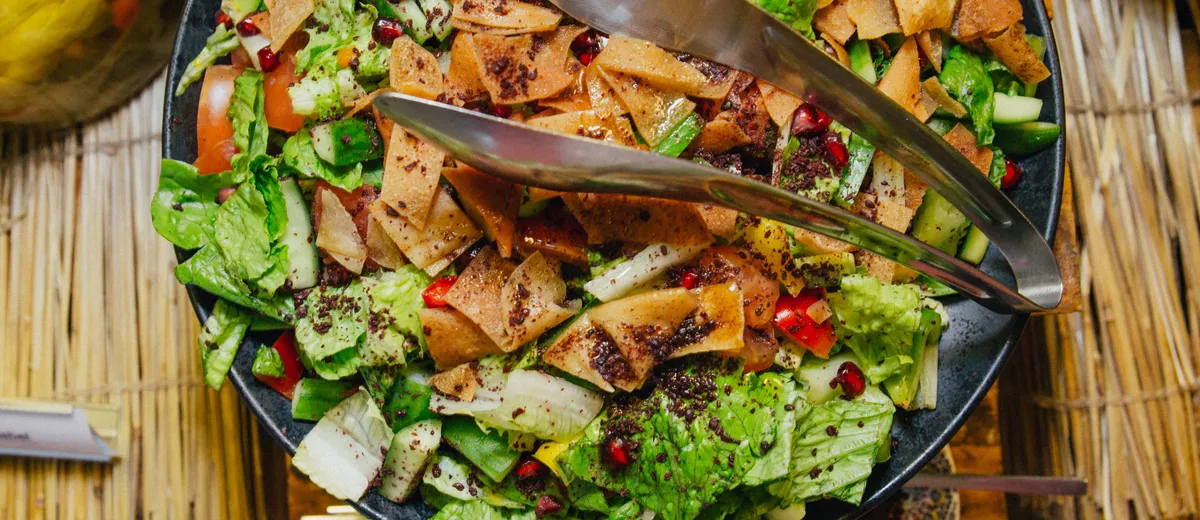 Fattouche libanaise, salade colorée de laitue, tomates, concombre et radis parsemée de sumac et de morceaux de pain pita grillé