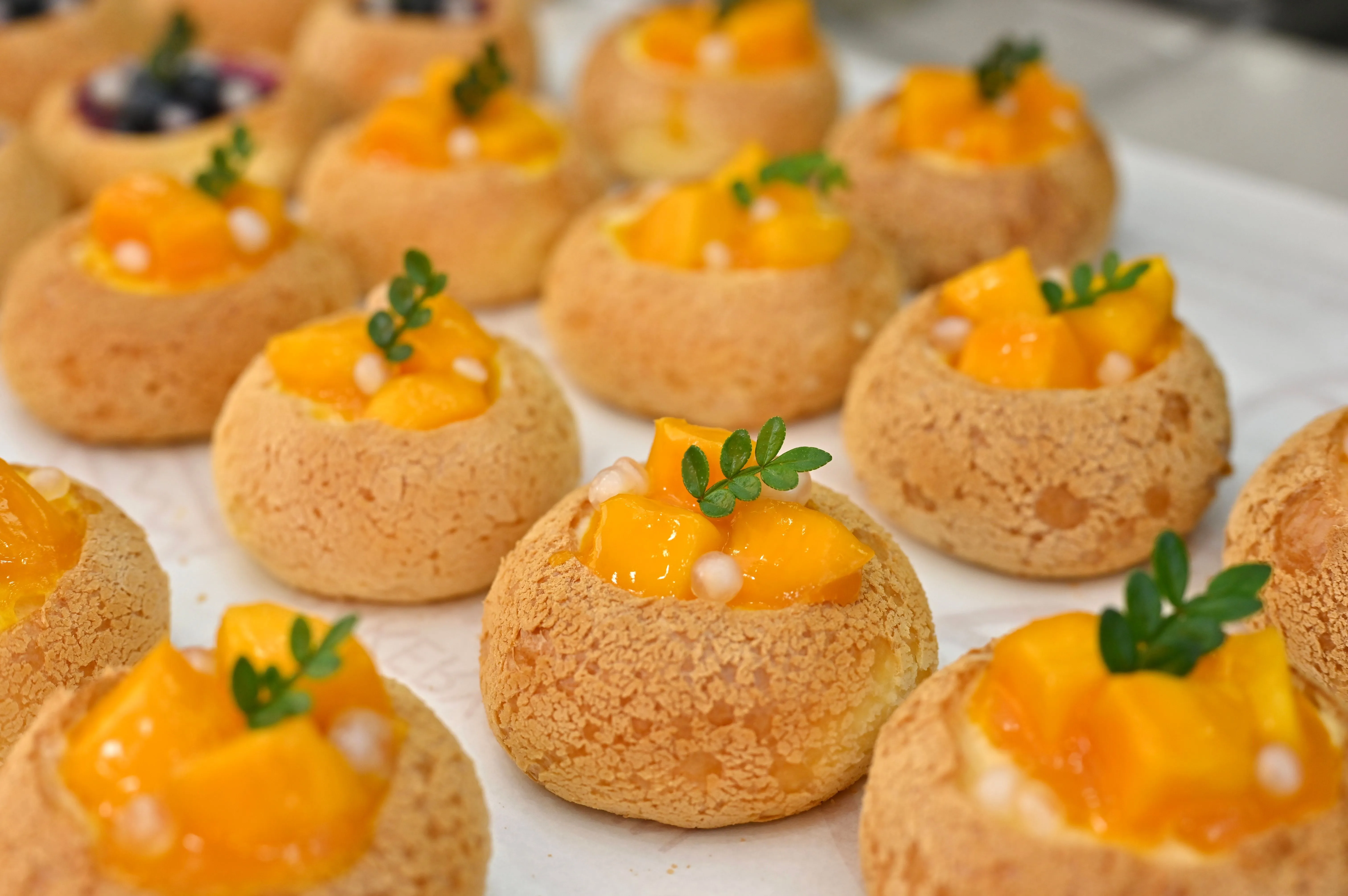 Gougères au fromage dorées, gonflées, sorties du four sur une grille