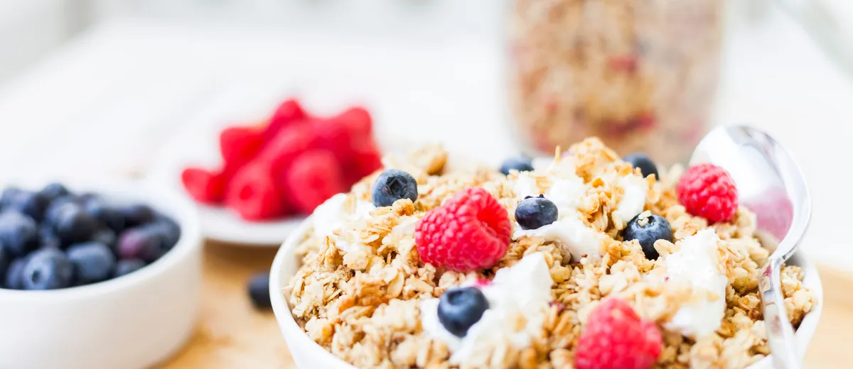 Granola maison croustillant en pépites dorées, amandes, noix, graines de courge et cranberries, dans un bol