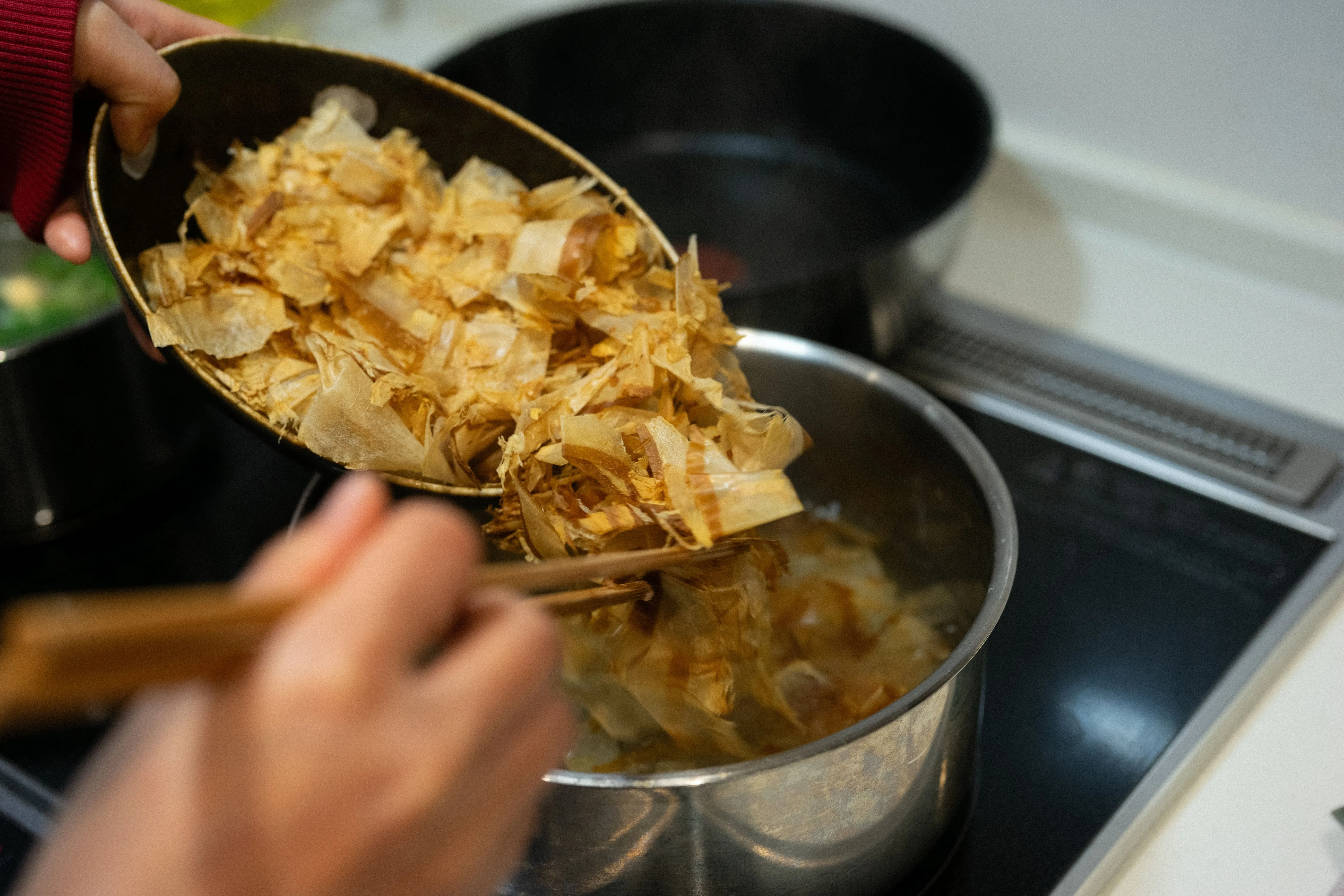 Algue kombu, copeaux de katsuobushi, riz et pâte de miso disposés sur un plan de travail en bois