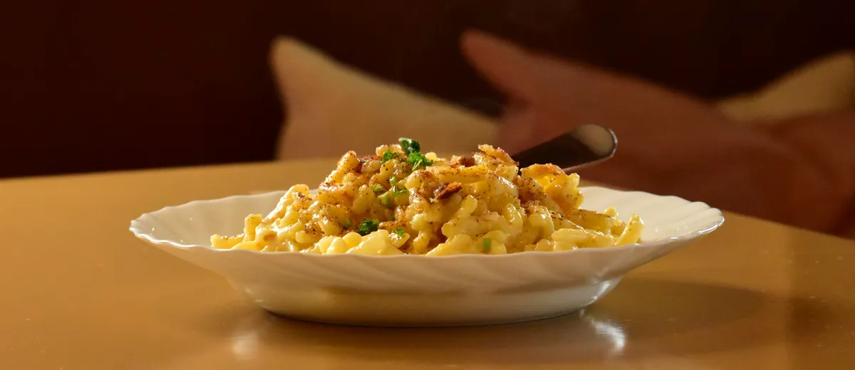 Käsespätzle gratinés au fromage fondant, garnis d'oignons dorés et de ciboulette