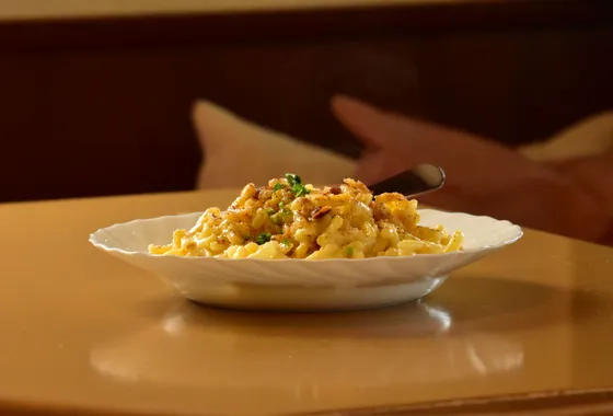 Käsespätzle gratinés au fromage fondant, garnis d'oignons dorés et de ciboulette