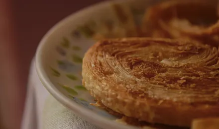 Kouign-amann breton doré et caramélisé, feuilletage brillant aux bords croustillants.