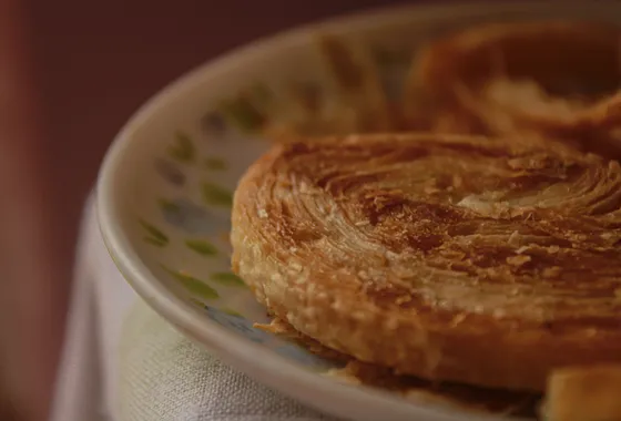 Kouign-amann breton doré et caramélisé, feuilletage brillant aux bords croustillants.