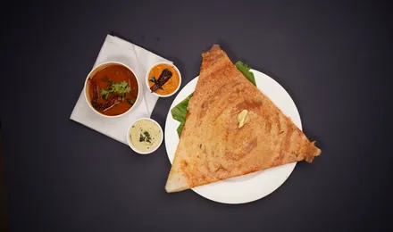 Masala dosa dorée et croustillante roulée sur une garniture de pommes de terre épicées, servie avec chutney à la noix de coco