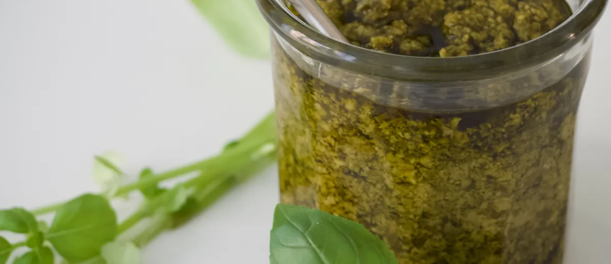 Bol de pesto alla genovese vert vif, avec basilic frais, pignons et parmesan autour