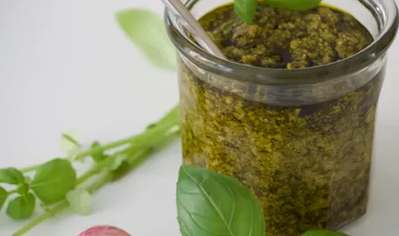 Bol de pesto alla genovese vert vif, avec basilic frais, pignons et parmesan autour
