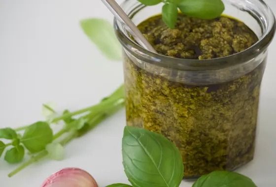 Bol de pesto alla genovese vert vif, avec basilic frais, pignons et parmesan autour