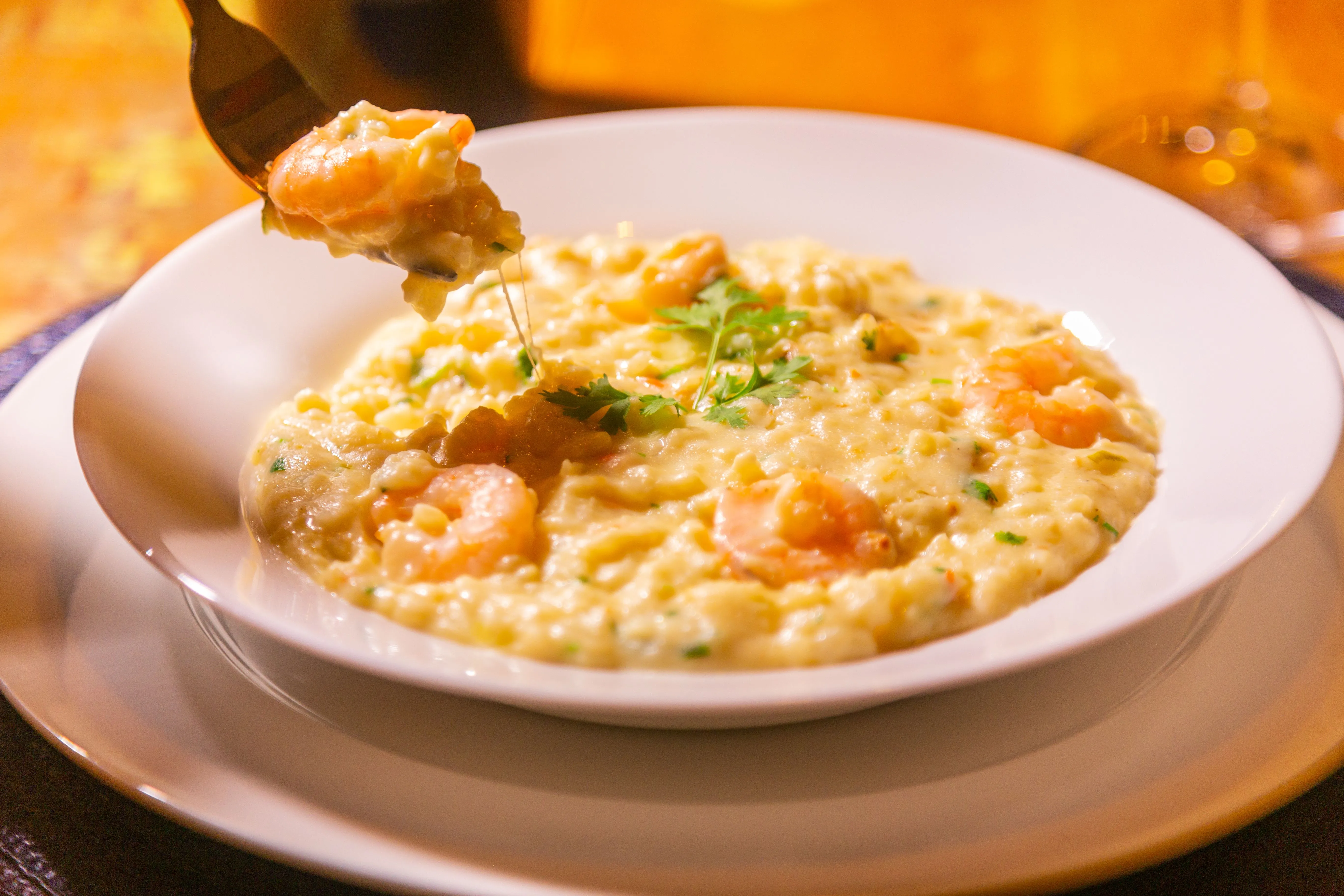 Risotto crémeux et brillant dans une assiette creuse, parsemé de parmesan
