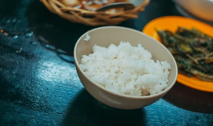 Riz vinaigré japonais brillant et collant dressé dans un bol en bois, prêt pour la préparation de sushis