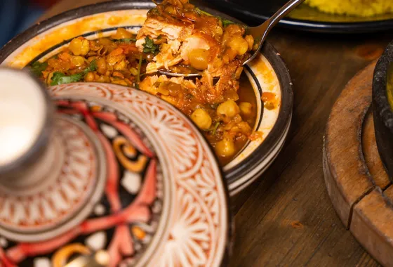 Tajine de poulet doré aux citrons confits et olives vertes, nappé d'une sauce safranée parsemée de coriandre
