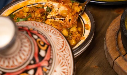 Tajine de poulet doré aux citrons confits et olives vertes, nappé d'une sauce safranée parsemée de coriandre