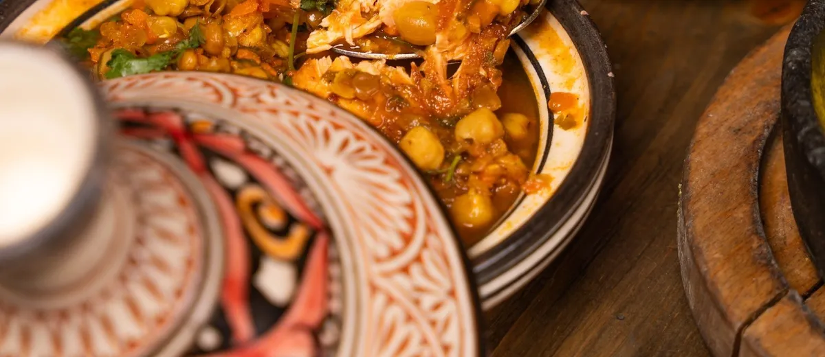 Tajine de poulet doré aux citrons confits et olives vertes, nappé d'une sauce safranée parsemée de coriandre