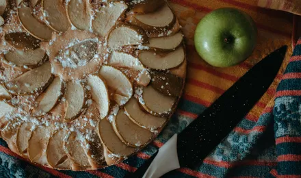 Tarte aux pommes classique, lamelles rangées en rosace sur un fond de compote, dorées et nappées d'abricot