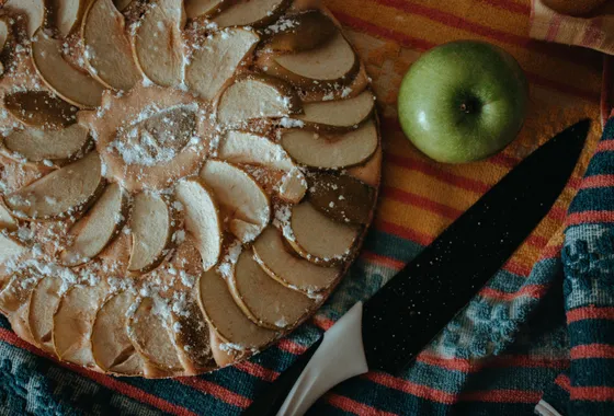 Tarte aux pommes classique, lamelles rangées en rosace sur un fond de compote, dorées et nappées d'abricot