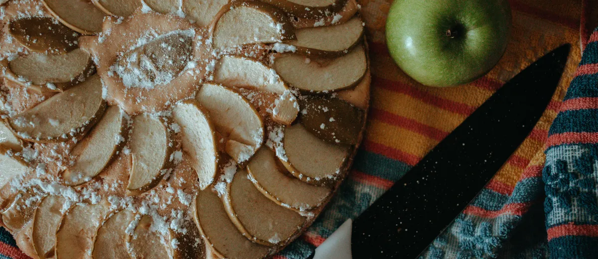 Tarte aux pommes classique, lamelles rangées en rosace sur un fond de compote, dorées et nappées d'abricot