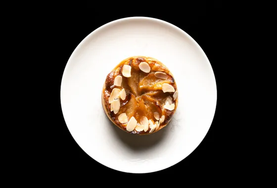Tarte Tatin aux pommes caramélisées démoulée, quartiers dorés et brillants de caramel sur une pâte brisée croustillante
