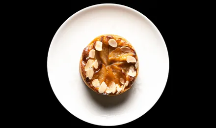 Tarte Tatin aux pommes caramélisées démoulée, quartiers dorés et brillants de caramel sur une pâte brisée croustillante