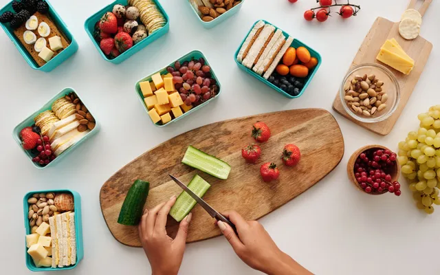 Boîtes hermétiques de plats maison étiquetés, prêts à congeler, alignés sur un plan de travail