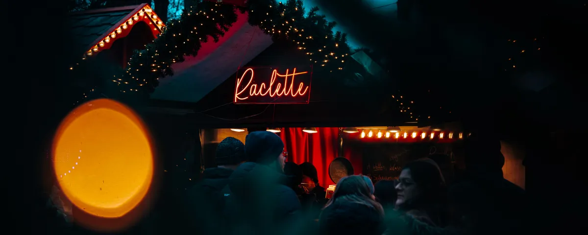Table d'hiver dressée pour une raclette conviviale, poêlons, charcuterie et pommes de terre