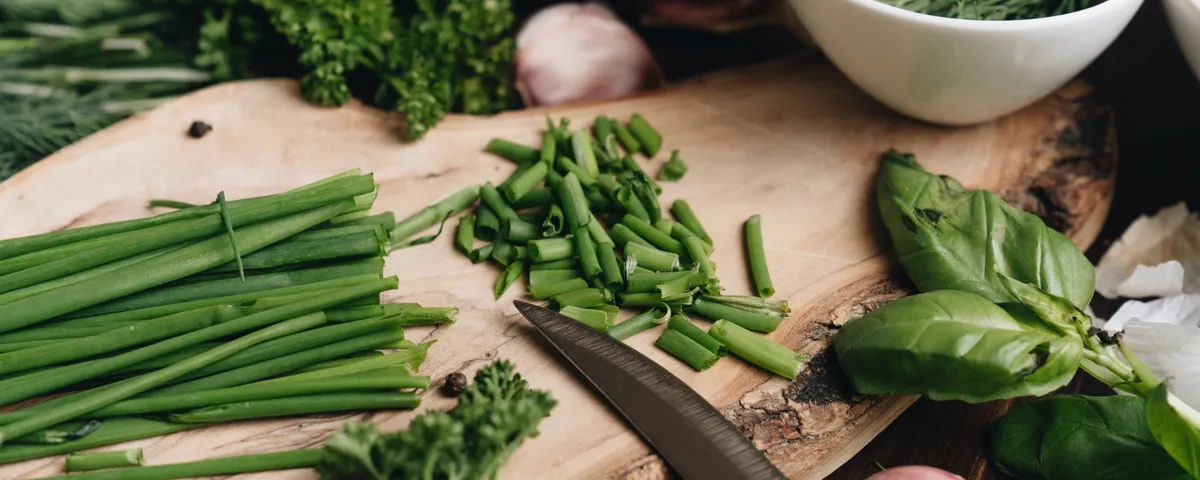 Assortiment d'herbes aromatiques fraîches en bottes — basilic, thym, persil, romarin — sur une planche en bois