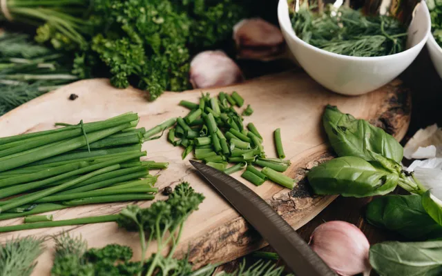 Assortiment d'herbes aromatiques fraîches en bottes — basilic, thym, persil, romarin — sur une planche en bois