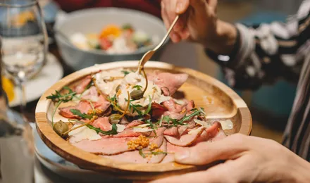 Fines tranches de veau froid dressées en assiette, nappées de sauce au thon crémeuse et décorées de câpres et de câprons