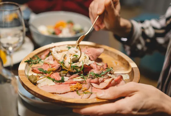 Fines tranches de veau froid dressées en assiette, nappées de sauce au thon crémeuse et décorées de câpres et de câprons