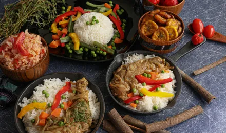 Yassa poulet sénégalais, cuisses dorées nappées d'une sauce épaisse aux oignons confits et citron, servi avec du riz blanc.