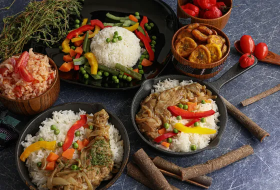 Yassa poulet sénégalais, cuisses dorées nappées d'une sauce épaisse aux oignons confits et citron, servi avec du riz blanc.